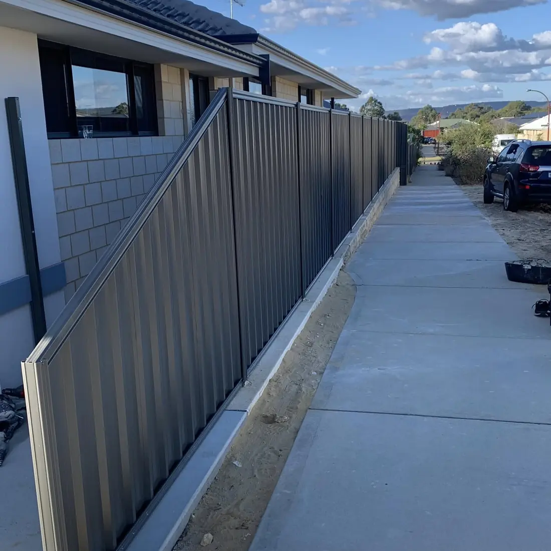 Charcoal Colorbond fence along a new concrete path