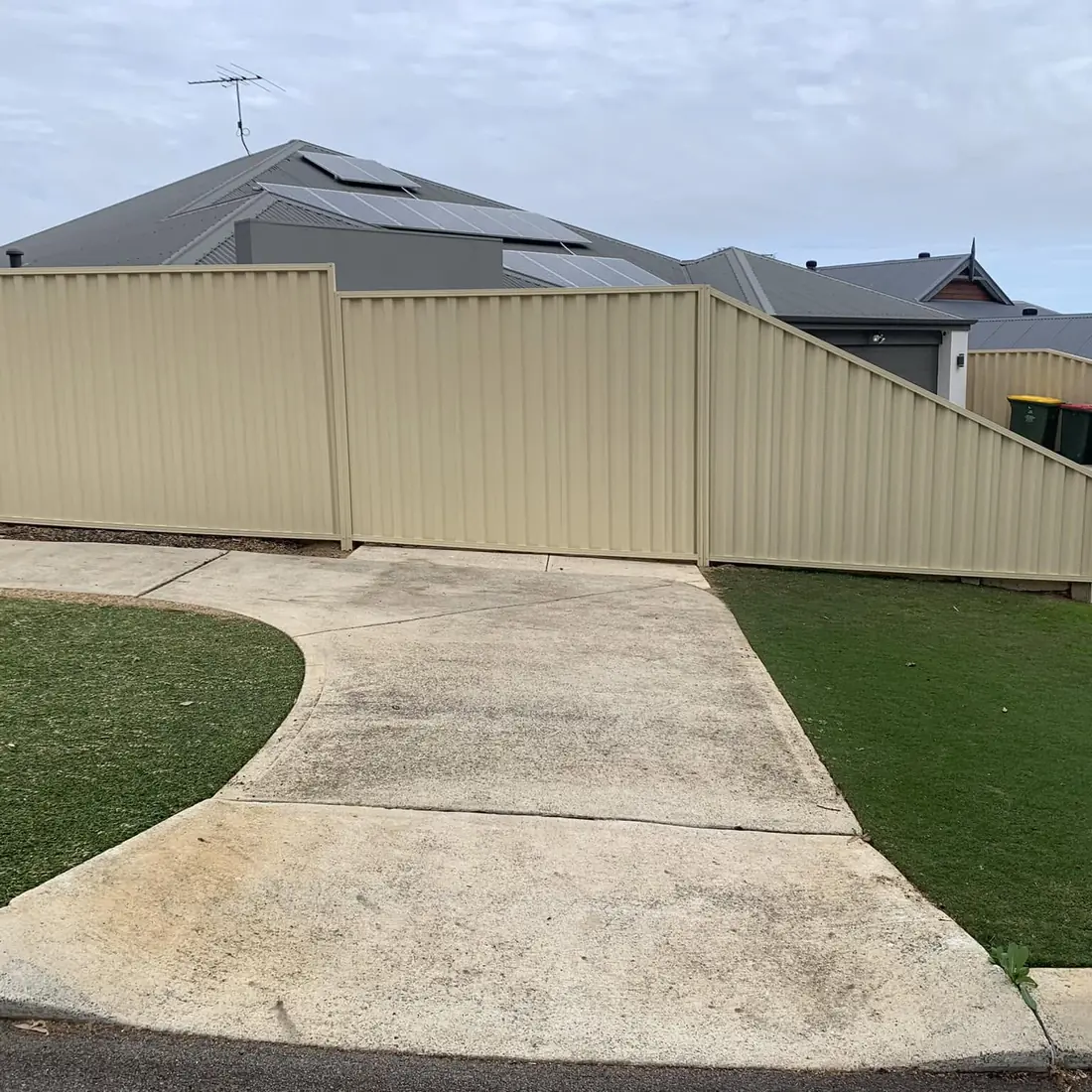 Cream Colorbond fence stepping down over a driveway